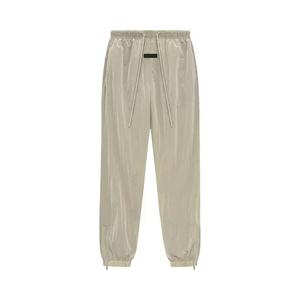 Fear of God Essentials Брюки из мятого нейлона с завязками 'Садово-желтый'